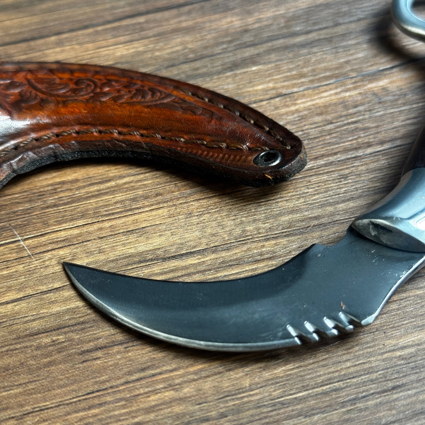 karambit knife with tooled leather sheath